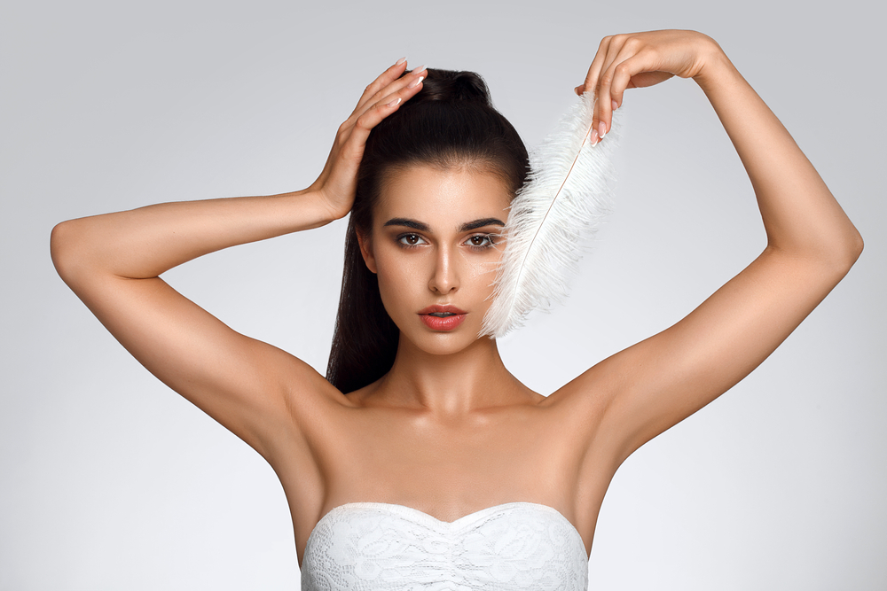Woman with arms up showing her sooth, hair-free underarms from laser hair removal in NYC Woman with arms up showing her sooth, hair-free underarms from laser hair removal in NYC