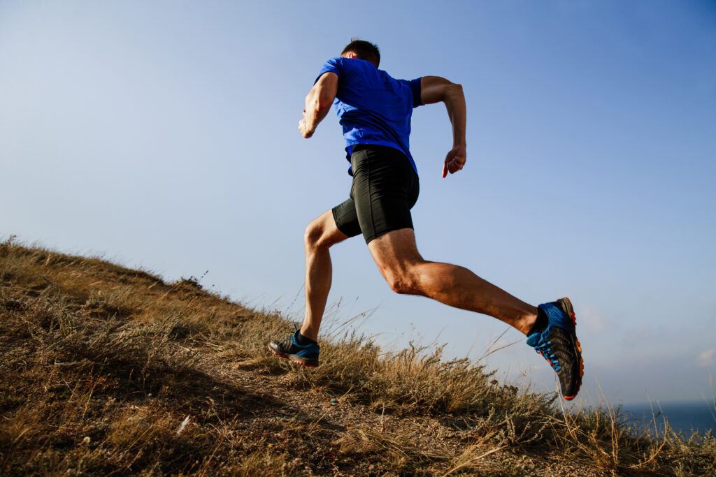 Male athlete running on a trail with smooth skin from laser hair removal in NYC
